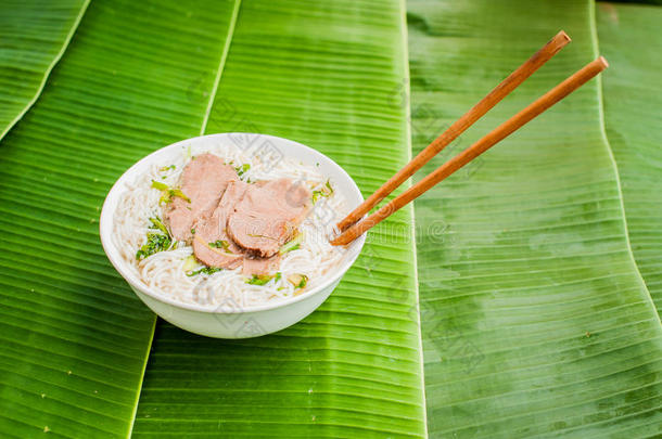 香蕉叶背景上的一碗传统越南牛肉汤。