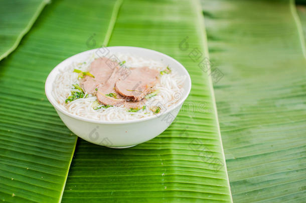 香蕉叶背景上的一碗传统越南牛肉汤。