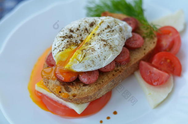美味的三明治与开放的荷包蛋，肉，费塔奶酪，番茄，草药，胡椒-快速早餐在咖啡馆