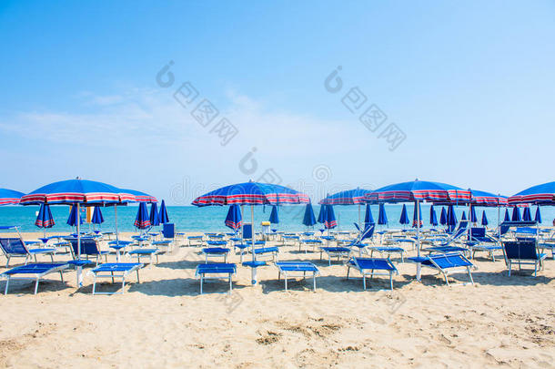 亚得里亚海海岸景观。 意大利海滨，夏日的雨伞在沙滩上，地平线上有云。