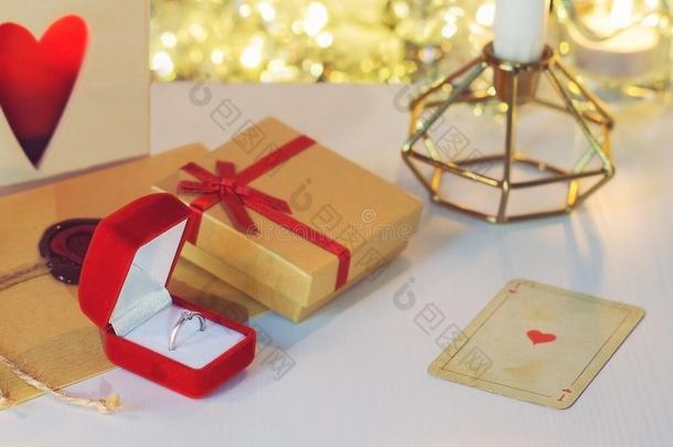 订婚戒指周围有礼物，蜡烛，心脏扑克牌