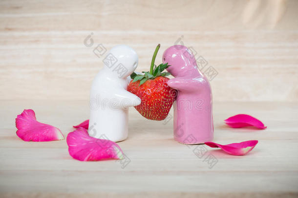 陶瓷玩具给一对夫妇一个草莓，因为他们的爱
