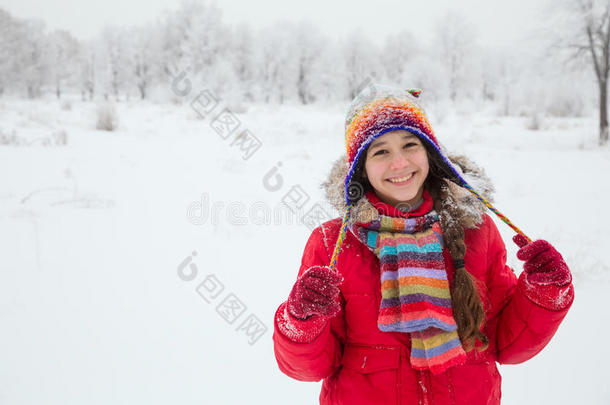 女孩站在雪景上穿着五颜六色的温暖衣服