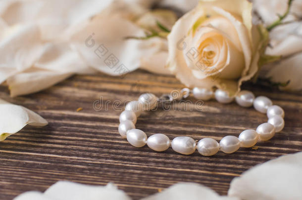 美丽的<strong>珍珠手镯</strong>在优雅的花背景上，特写