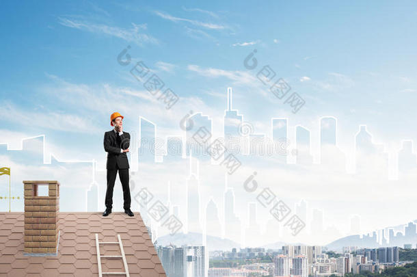 工程师站在屋顶上<strong>看</strong>着<strong>远方</strong>。 混合媒体
