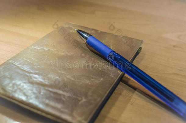 木桌上的蓝色墨水圆珠笔和文件