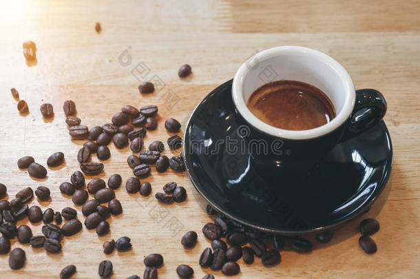 在木桌上<strong>洒下</strong>咖啡豆的黑咖啡杯