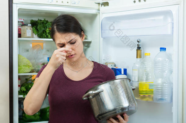 愤怒和沮丧的家庭主妇看着锅与肮脏的<strong>饭</strong>菜