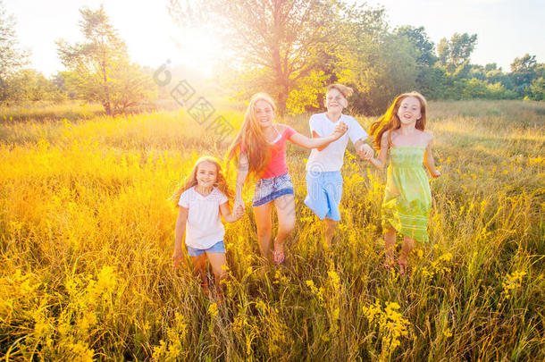 四个快乐的美丽的孩子在美丽的夏天一起奔跑，一起玩耍。