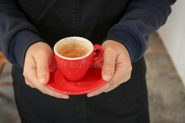 咖啡师端着一杯意式咖啡向顾客赠送