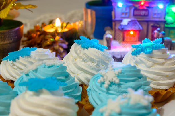 圣诞奶油蛋糕和蜡烛在桌子上用彩灯靠近