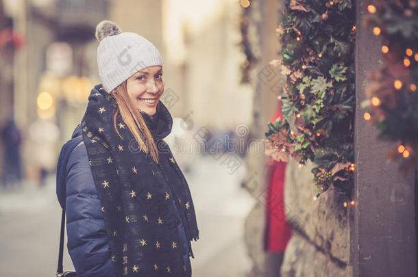 美丽的微笑的女人在圣诞节的冬天在街上