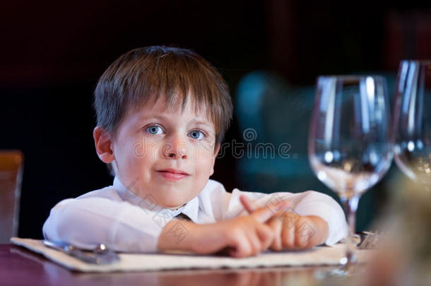 可爱的蹒跚学步的男孩在一家高档餐厅