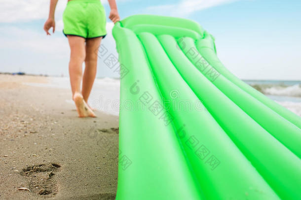 沙滩上的脚印-带着游泳床垫的男孩在沙滩上散步