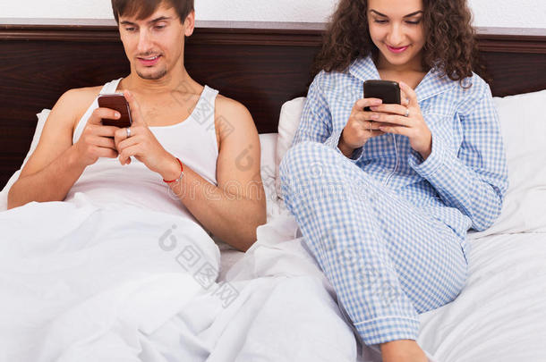 男朋友和漂亮的女朋友忙于智能手机