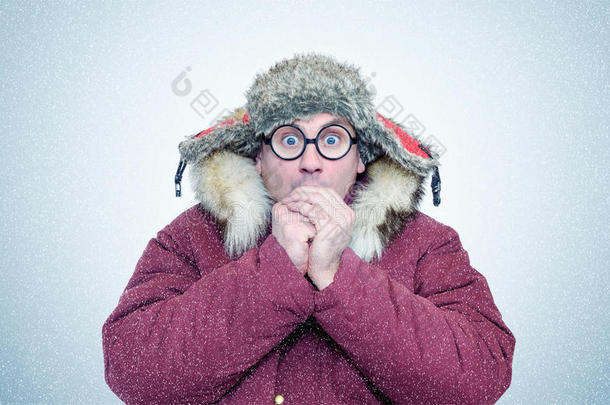冰冻的男人穿着冬天的衣服和眼镜，温暖的手，寒冷，雪，暴风雪