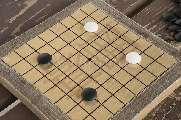 中国人去还是围棋棋盘游戏。 黑白石头和手工制作的小木板。