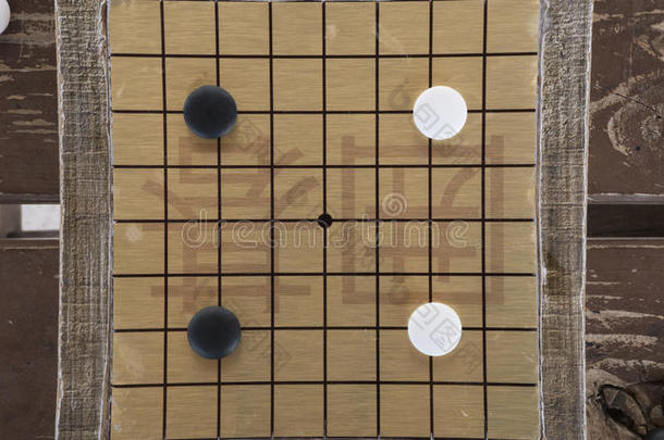 中国人去还是围棋棋盘游戏。 黑白石头和手工制作的小木板。