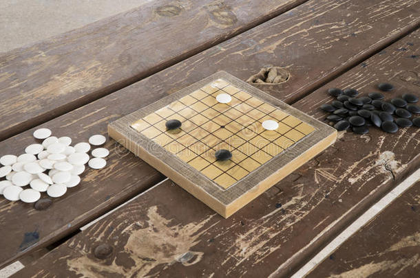 中国人去还是围棋棋盘游戏。 黑白石头和手工制作的小木板。