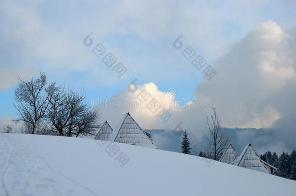 小屋在雪下，山和天空在后面