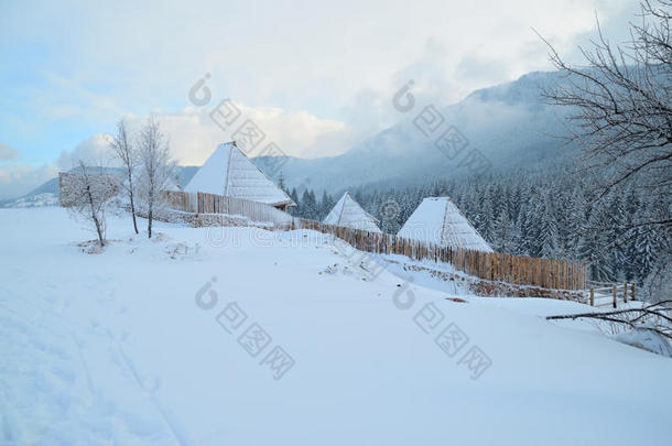 雪下的小屋，被木栅栏<strong>包围</strong>着