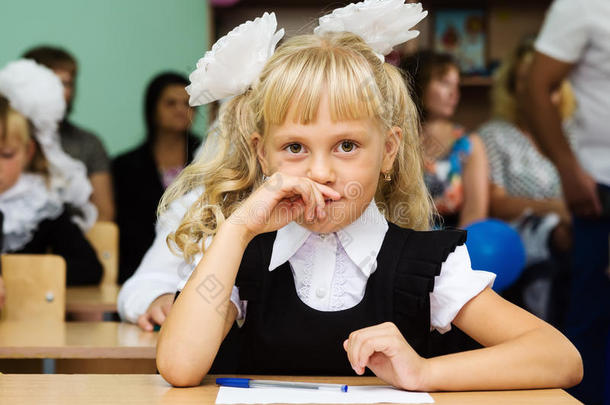 一年级的女孩坐在第一节课的桌子旁