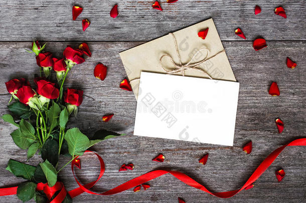 空白白色贺卡与红玫瑰花束，信封和花瓣