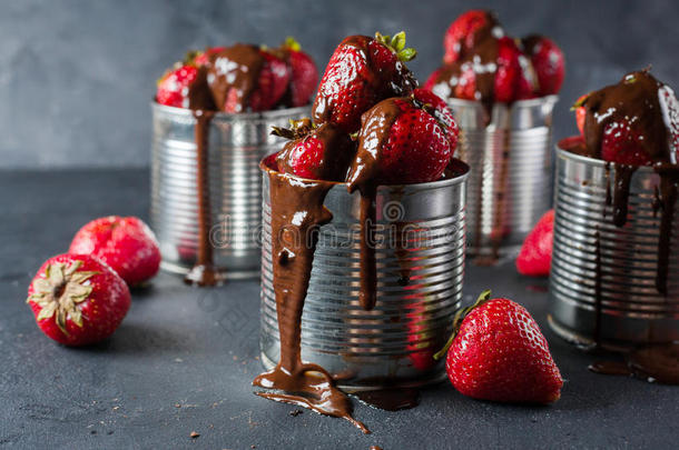 灰色背景的新鲜草莓。 甜点加草莓和巧克力，焦糖。 铁锅里的草莓