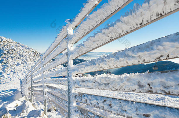在一个晴朗的冬天，在一场暴风雪之后，栅栏被大雪覆盖