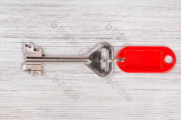 木制桌子上有红色钥匙链的大门钥匙
