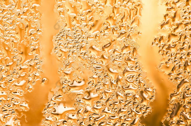 玻璃窗上抽象的金色框架和水滴图案。 液体纹理气泡宏观视图。 很浅的深度