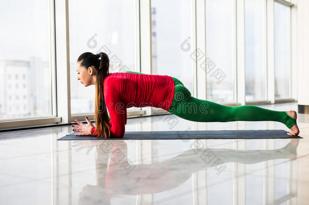 阿什瓦·桑查拉萨纳。 美丽的瑜伽女子在一个大窗口大厅练习