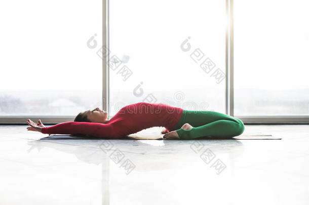 美丽的瑜伽女人在灰色背景上练习瑜伽姿势。