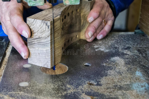 木匠工作场所-木匠工作场所。 用锯子砍木头的人