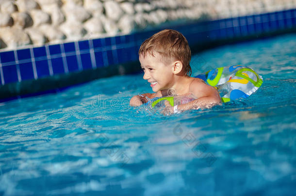 男孩漂浮在游泳池里的充气圆圈上。 游<strong>进度</strong>假村