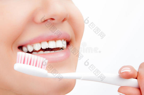 美丽的年轻女子刷牙微笑。 牙科健康背景。