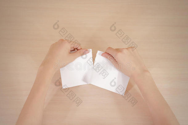 双手撕一张纸，半张空白的白色传单小册子。 小册子介绍。 小册子牵着手。 显示清楚