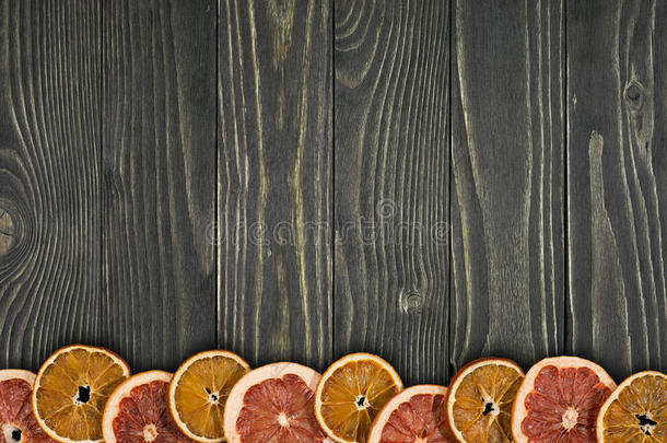 干橘子和葡萄柚在旧的深色木桌上。