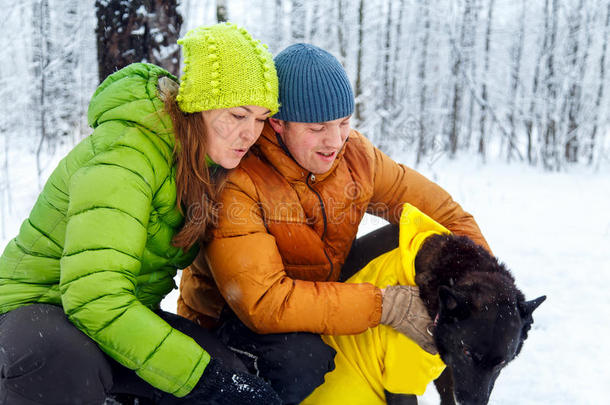 活跃的家庭在冬天的森林里遛狗。