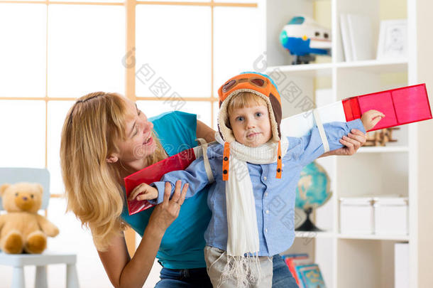 小男孩穿得像个飞行员，在家里玩玩具翅膀