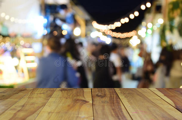 模糊的图像木桌和食物在夜间节日与Bokeh