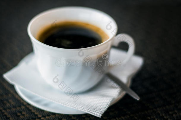 在餐厅用餐巾纸放在茶托上的一杯速溶咖啡，