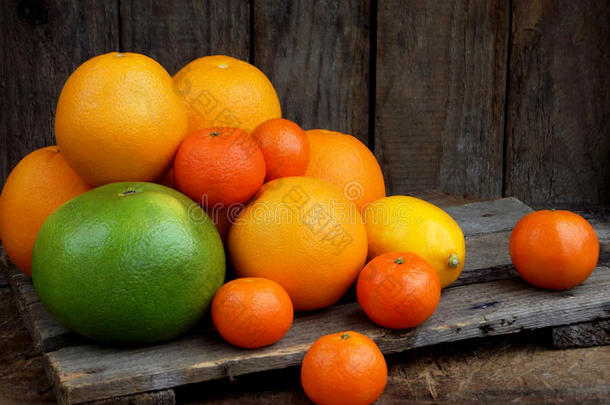 木制背景下柑橘的组成：橘子、橘子、甜心、柠檬。 侧视图