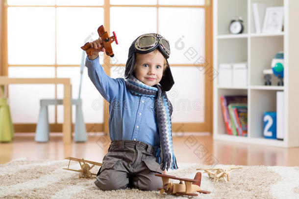 假装是飞行员的孩子。 孩子在家里玩玩具飞机