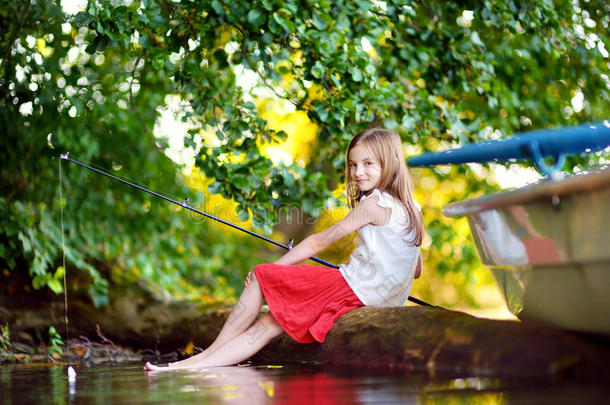 可爱的小女孩在河边的船上玩得很开心