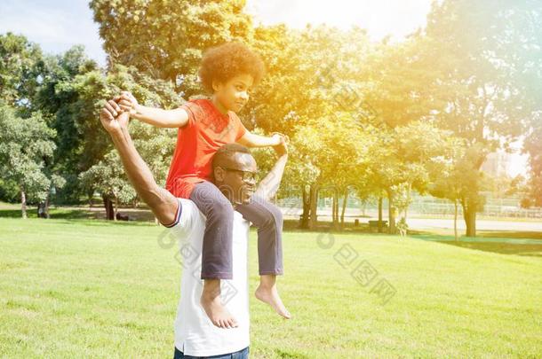 非裔美国人家庭在夏天在户外公园里做背驮和玩