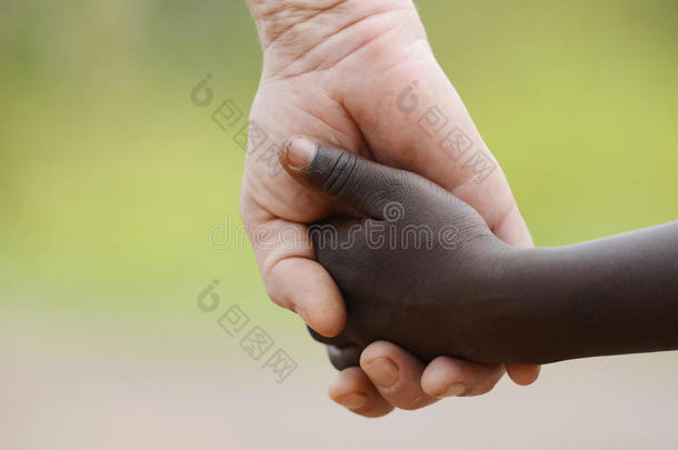 美丽的和平象征-白人妇女黑人儿童牵手。