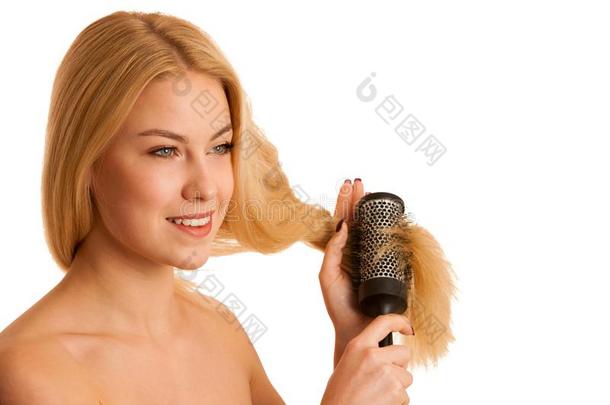 美丽的金发女人刷她的头发<strong>作为</strong>一个标志，OG头发护理