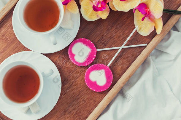情人节在床上吃早餐。 一杯茶和甜糖果。 爱情或假日概念