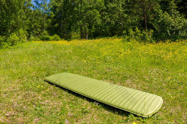 绿色充气露营床垫在绿色的草地上